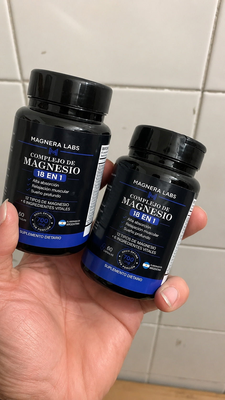 Frascos de Magnera Labs Complejo de Magnesio 18 en 1 sostenidos en la mano